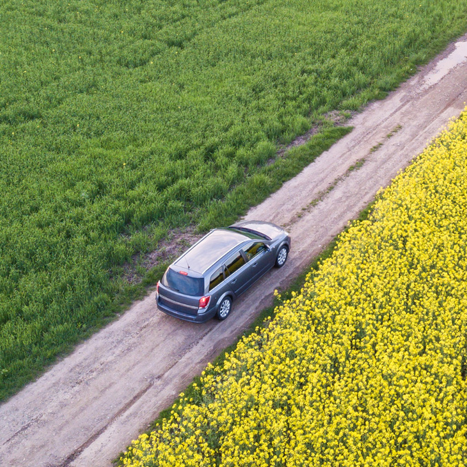 Aerial view of a silver SUV on a dirt road - https://www.sartori-insurance.com/