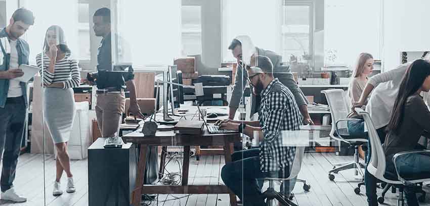 Open-plan office with people collaborating at desks - https://www.sartori-insurance.com/